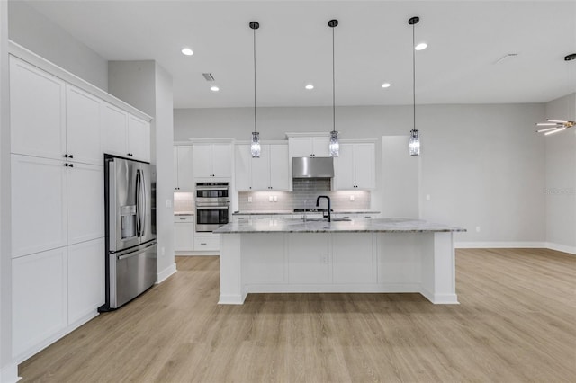 kitchen featuring white cabinets, an island with sink, stainless steel appliances, and light hardwood / wood-style floors