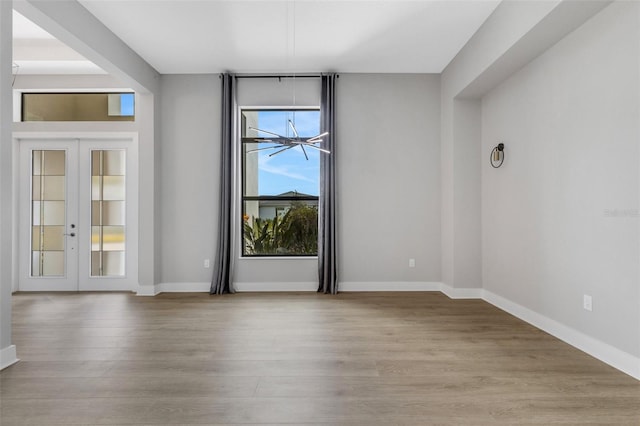 empty room with light hardwood / wood-style flooring and french doors