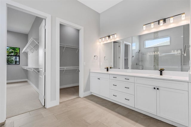 bathroom with vanity, an enclosed shower, and a wealth of natural light