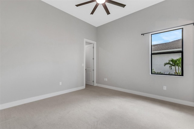 carpeted spare room featuring ceiling fan and lofted ceiling