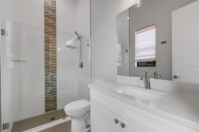 bathroom featuring a shower with shower door, vanity, and toilet