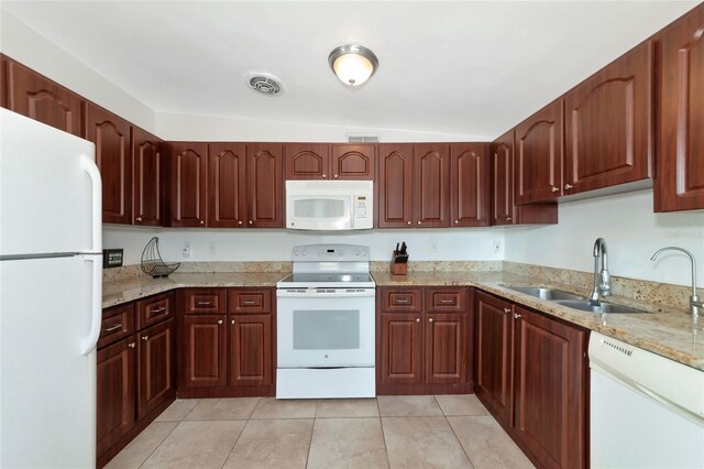 kitchen featuring light stone counters, sink, vaulted ceiling, white appliances, and light tile patterned floors