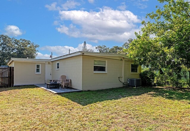 back of house with a lawn, central air condition unit, and a patio area