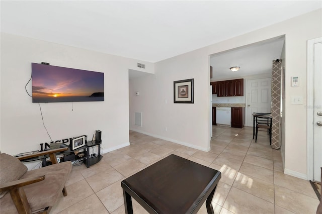 living room with light tile patterned floors, baseboards, and visible vents