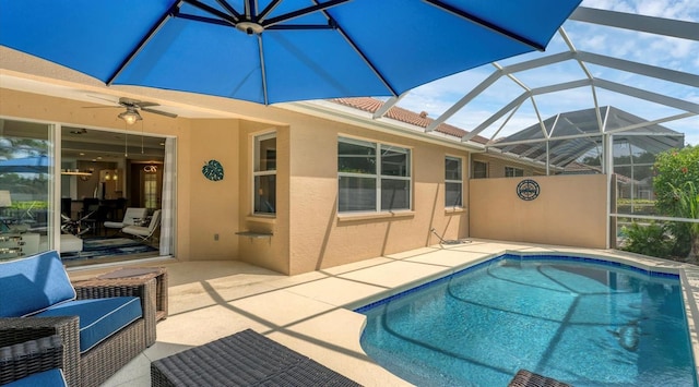 view of swimming pool with ceiling fan, glass enclosure, and a patio