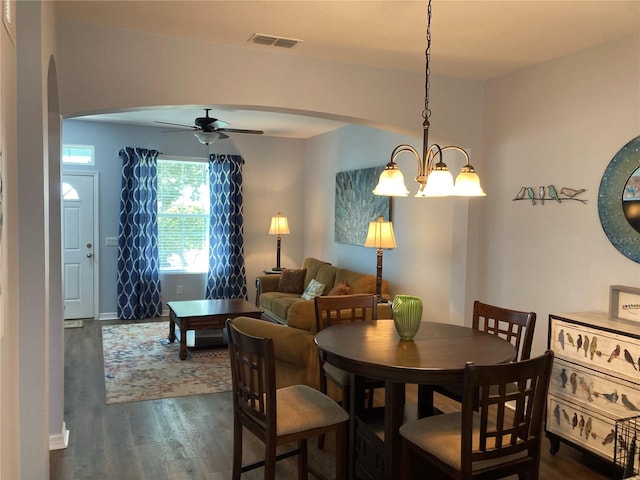 dining area featuring ceiling fan with notable chandelier and dark hardwood / wood-style floors