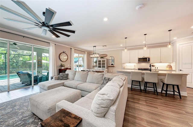 3360 Chestertown Loop, Bradenton, FL 34211 - living area featuring crown molding, wood finished floors, ceiling fan, and recessed lighting