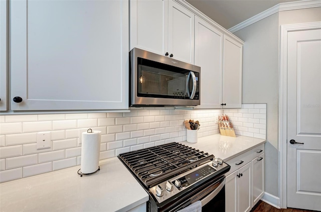 3360 Chestertown Loop, Bradenton, FL 34211 - kitchen with stainless steel appliances, crown molding, white cabinetry, light countertops, and decorative backsplash