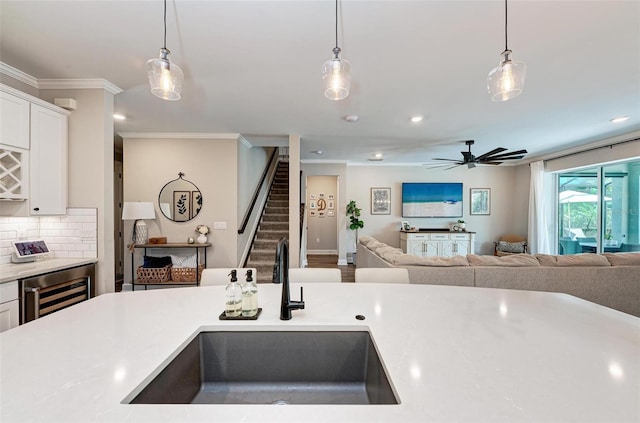 3360 Chestertown Loop, Bradenton, FL 34211 - kitchen with a sink, wine cooler, ornamental molding, pendant lighting, and light countertops
