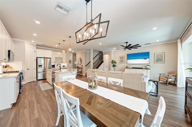 3360 Chestertown Loop, Bradenton, FL 34211 - dining area with recessed lighting, ornamental molding, visible vents, ceiling fan with notable chandelier, and wood finished floors
