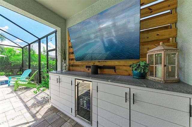 view of patio featuring glass enclosure and wine cooler