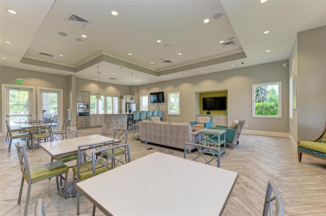 dining room with a tray ceiling and light parquet flooring