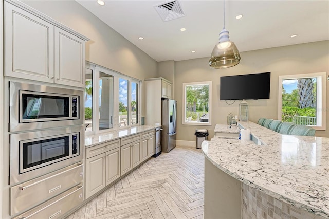 kitchen featuring appliances with stainless steel finishes, light parquet floors, and a healthy amount of sunlight