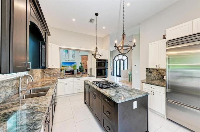 kitchen with hanging light fixtures, a kitchen island, sink, dark brown cabinetry, and stainless steel appliances