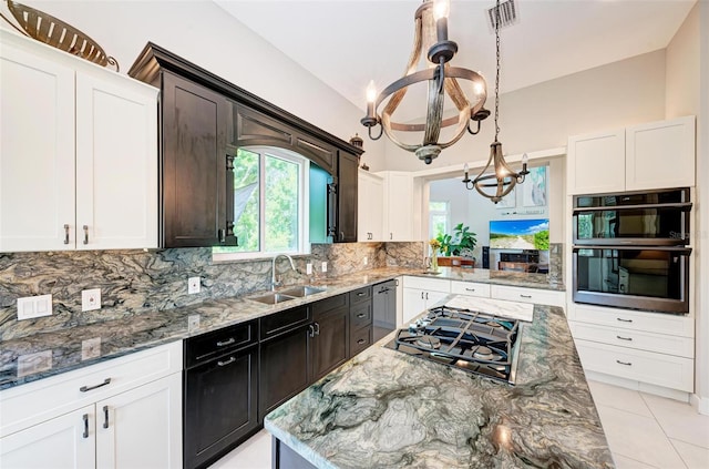 kitchen with decorative backsplash, stainless steel appliances, a notable chandelier, decorative light fixtures, and sink