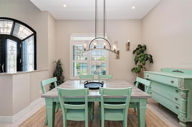 tiled dining room with a notable chandelier