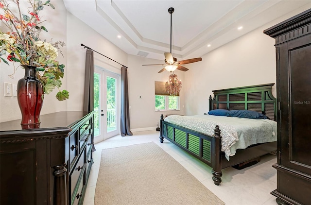 bedroom with ceiling fan, access to outside, and a tray ceiling