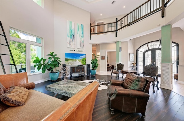 living room featuring french doors, a towering ceiling, and dark hardwood / wood-style floors