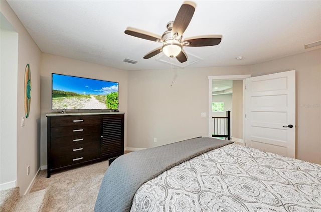 bedroom featuring ceiling fan, multiple windows, and light colored carpet