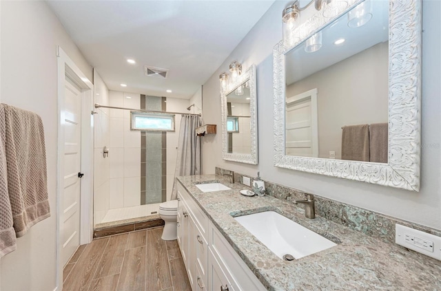 bathroom with vanity, toilet, curtained shower, and hardwood / wood-style floors