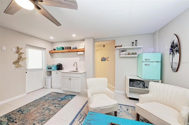 living area featuring sink, ceiling fan, and light tile patterned floors