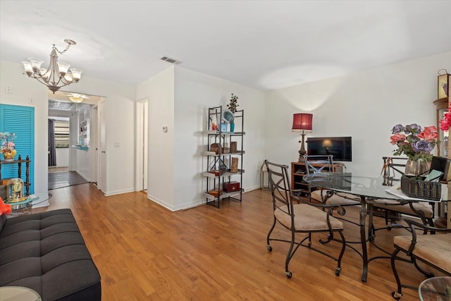 dining area with a notable chandelier and wood-type flooring