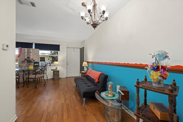 sitting room with an inviting chandelier and hardwood / wood-style floors