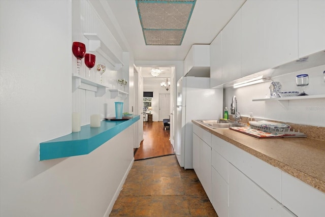 kitchen with white cabinetry, sink, dark hardwood / wood-style flooring, and white fridge