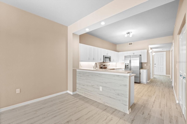 kitchen featuring appliances with stainless steel finishes, light wood-type flooring, white cabinets, and kitchen peninsula