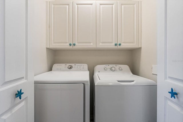 laundry area with washer and dryer and cabinets