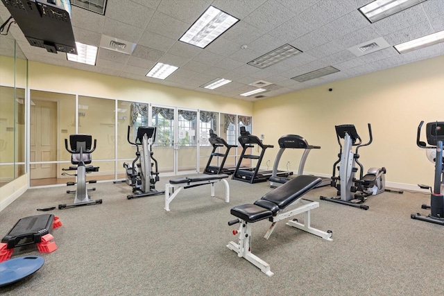 exercise room featuring a paneled ceiling, visible vents, and baseboards