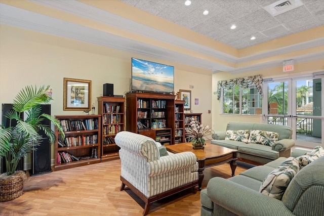 interior space with recessed lighting, visible vents, ornamental molding, light wood-type flooring, and a raised ceiling