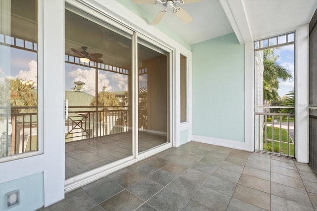 unfurnished sunroom with ceiling fan