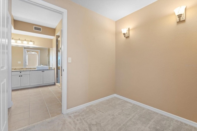 corridor featuring sink and light colored carpet