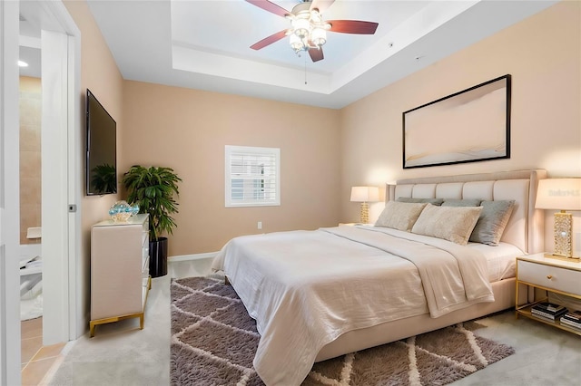 bedroom with baseboards, ceiling fan, a raised ceiling, and light colored carpet