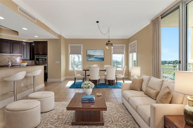 living room with ornamental molding and light tile patterned floors