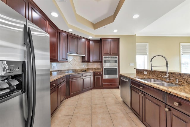 kitchen featuring stainless steel appliances, sink, light stone countertops, light tile patterned floors, and decorative backsplash