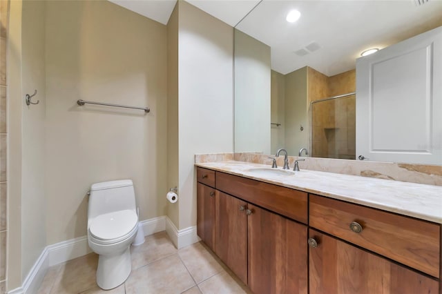 bathroom with tile patterned flooring, vanity, toilet, and a tile shower