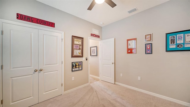 unfurnished bedroom with ceiling fan, a closet, and light carpet