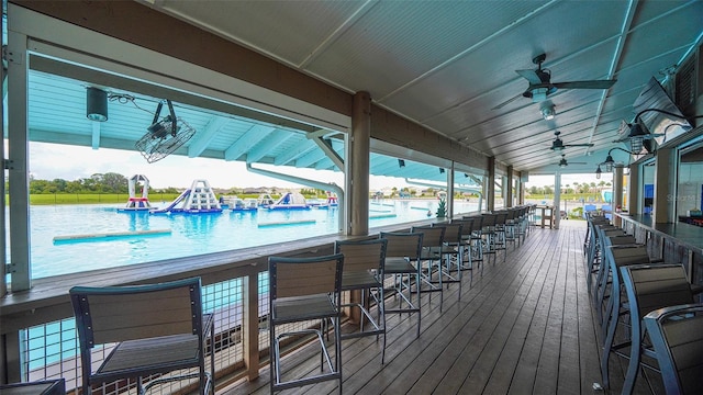 exterior space featuring ceiling fan, a water view, and exterior bar