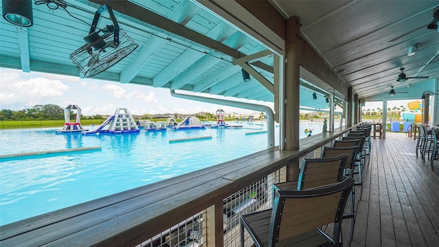 view of swimming pool featuring a water view and ceiling fan