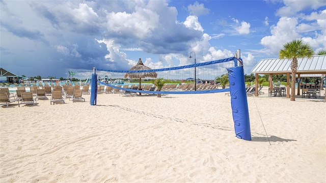 view of property's community with volleyball court, a gazebo, and a water view