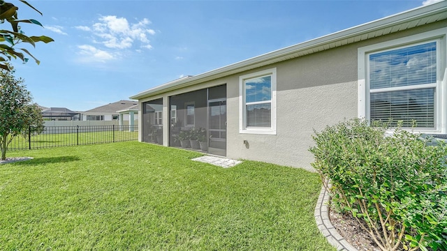 rear view of property featuring a sunroom and a yard