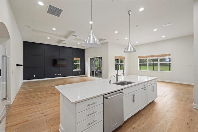 kitchen with hanging light fixtures, white cabinetry, stainless steel dishwasher, sink, and a spacious island