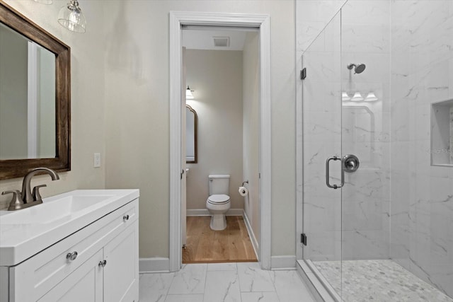 bathroom with a shower with shower door, hardwood / wood-style flooring, vanity, and toilet