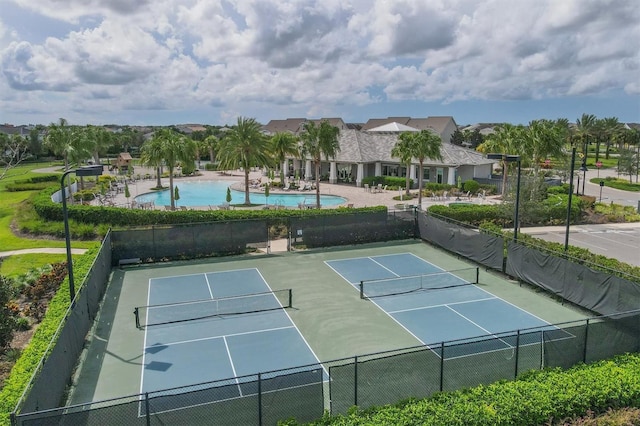 view of tennis court with a community pool