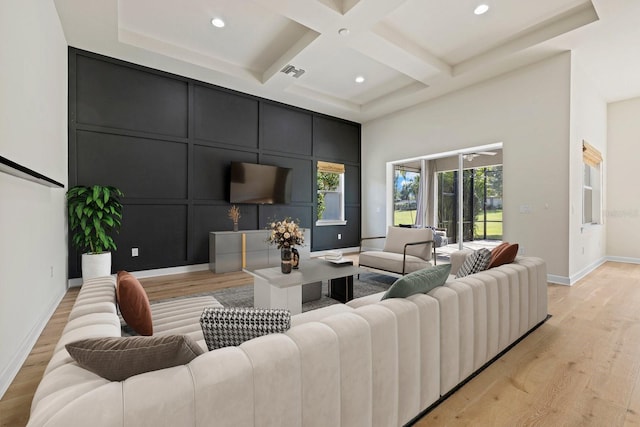 living room with light hardwood / wood-style flooring, beam ceiling, and coffered ceiling