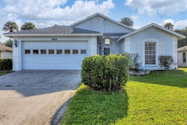 ranch-style home featuring a garage and a front lawn