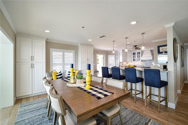 dining space featuring light hardwood / wood-style floors, ceiling fan, and crown molding