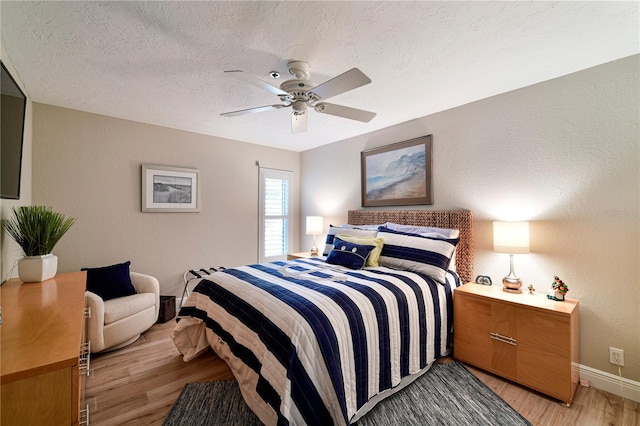 bedroom with a textured ceiling, light hardwood / wood-style flooring, and ceiling fan